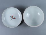 pair of chinese porcelain bowls with floral designs on them on a gray surface