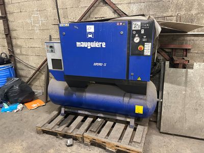 a blue compressor sitting on a pallet in a garage