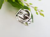 a close up of a silver ring with a face on it
