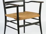 a black wooden chair with a woven seat and armrest