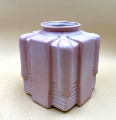 a purple vase sitting on a table with a white background