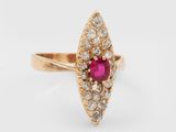 gros plan d'une bague en or avec un rubis et des diamants
