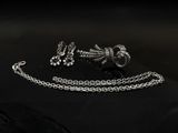 un gros plan sur une paire de bijoux en argent posés sur une surface noire