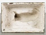 a small white vase with a hole in it