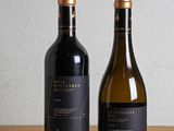 two bottles of wine sitting on top of a wooden table