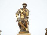 a statue of a man sitting on top of a table
