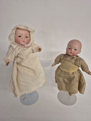 two dolls that are sitting next to each other on a table