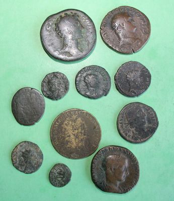 some old roman coins on a green surface with a green background