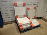 une pile de cartons posée sur une palette devant un mur