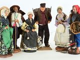 five figurines of people dressed in traditional clothing
