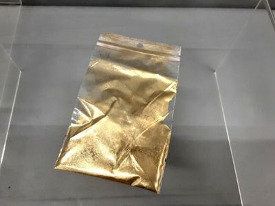 un sachet en papier doré exposé dans une vitrine en verre