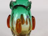 a glass vase with a green and orange design on it