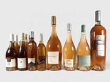 plusieurs bouteilles de vin sont alignées sur une surface blanche