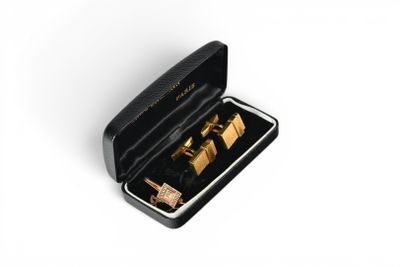 gold cufflinks in a black box on a white surface