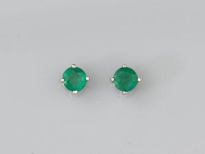 une paire de boucles d'oreilles en émeraude sur fond blanc