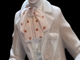 a white statue of a man with a hat and a cane