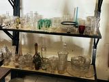 une étagère sur laquelle sont posés de nombreux verres, dans une pièce