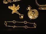a lot of gold jewelry on a black table