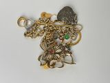 un tas de bijoux en or et en argent posés sur une surface blanche
