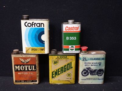 Plusieurs bidons d'huile moteur sont alignés sur une surface noire