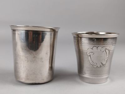 two silver cups sitting next to each other on top of a table