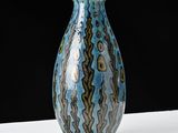 a blue and brown vase sitting on a white table