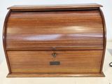 an old wooden roll top desk with a drawer on top of it