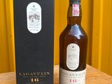 La bouteille de Lagavulin se trouve à côté de la boîte, sur la table.