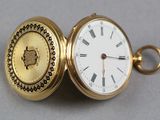 une montre de poche en or avec des chiffres romains