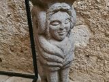 une statue en pierre représentant un enfant tenant un oiseau sur la tête