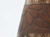 a close up of a vase with a brown design on it
