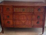 a wooden dresser with a mirror on top of it