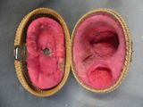 pair of pink slippers in a wicker basket on top of a table