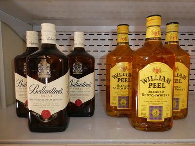 Plusieurs bouteilles d'alcool sont alignées sur une étagère dans un réfrigérateur