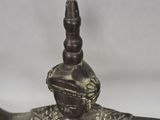 bronze figurine of a woman with a hat on her head