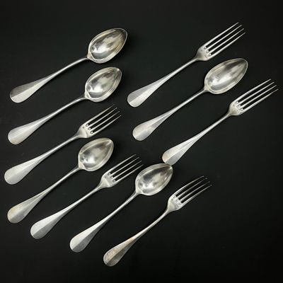 six cuillères en argent et six cuillères en argent posées sur un fond noir