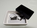 a black cell phone in a white box with a charger