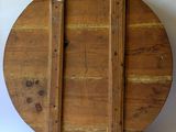 an image of a round wooden table with two wooden handles