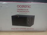 packaging of a microwave sitting on a table in front of a blue wall