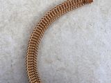 a close up of a gold chain bracelet on a concrete surface