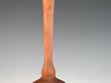 un vase en bois posé sur une table près d'un mur blanc