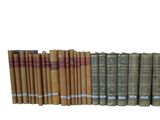 several old books are lined up in a row on a white surface