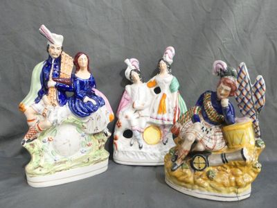 three figurines of people sitting on top of each other
