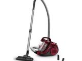 Un aspirateur rouge est posé à côté d'un aspirateur noir et blanc