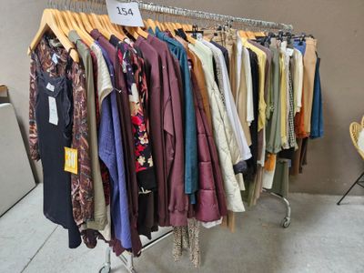 beaucoup de vêtements suspendus à une étagère dans une pièce