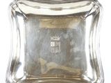 un plateau d'argent antique sur un support sur fond blanc