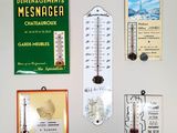 de nombreuses affiches différentes accrochées au mur, au-dessus du thermomètre