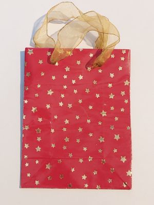 a red bag with gold stars on it sitting on a white surface