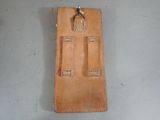 a tan leather case with a metal hook on it