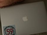 un ordinateur portable posé sur un canapé, sur lequel est collé un autocollant